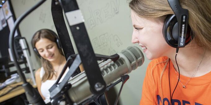 Students in a radio broadcasting room 