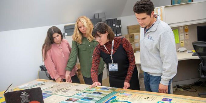 Group of students examining content on a table
