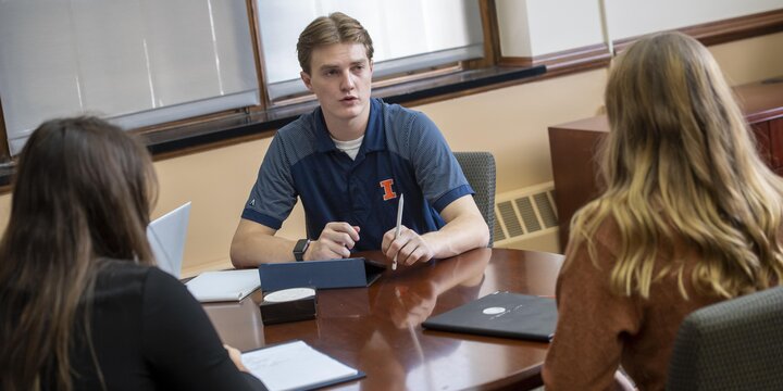 Three students talking with each other.